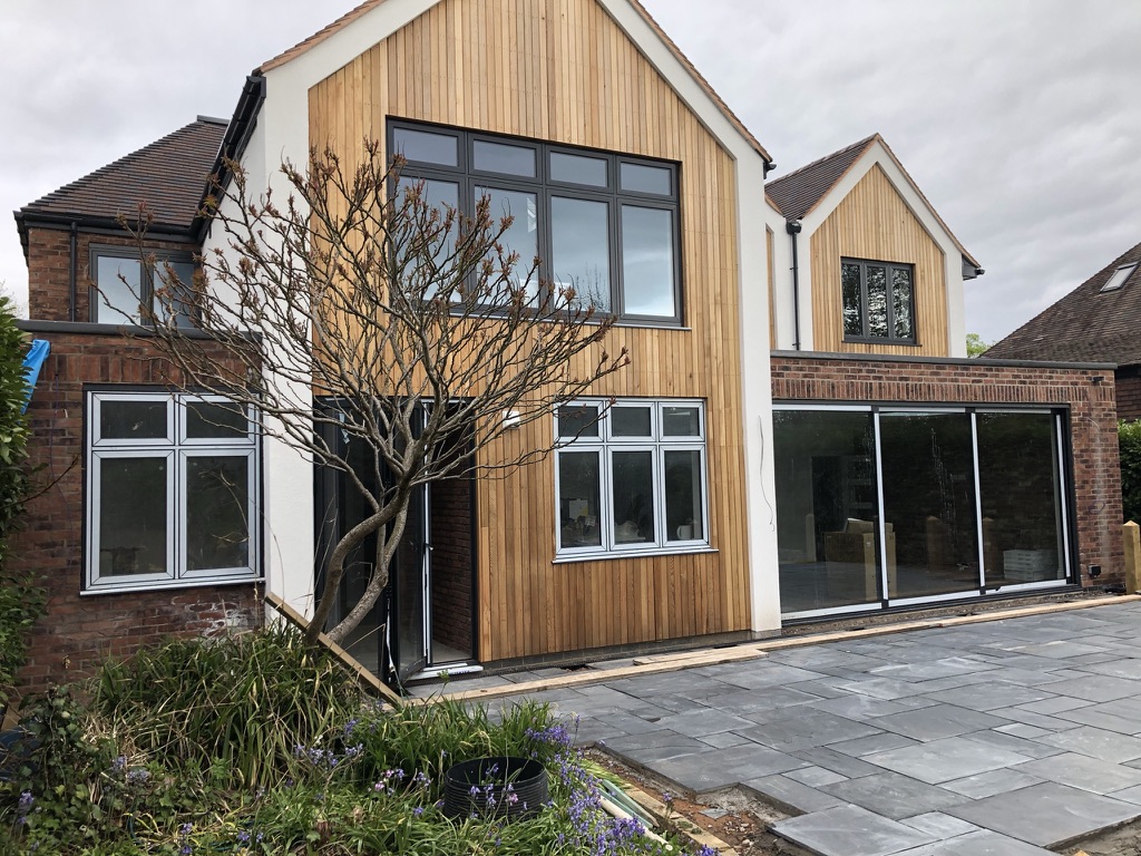 Timber-clad gables, brickwork and large garden doors
